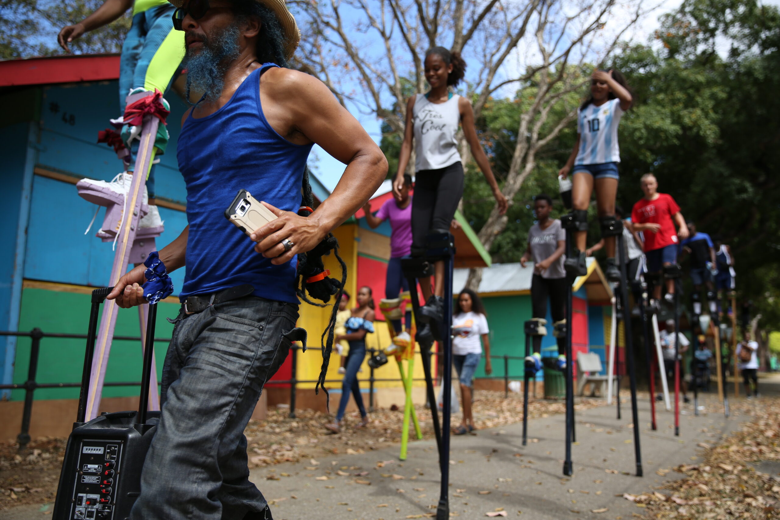 A group of people walk on stilts in a procession.