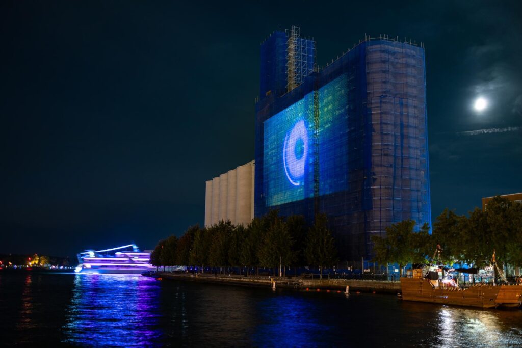 Video film projected against the Canadian Malting Silos building at night. Photo taken from across pier. 