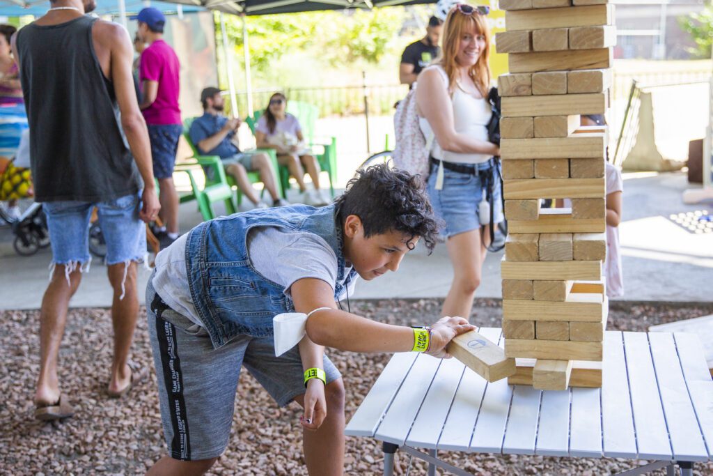 A student plays with large Jenga blocks at an event.