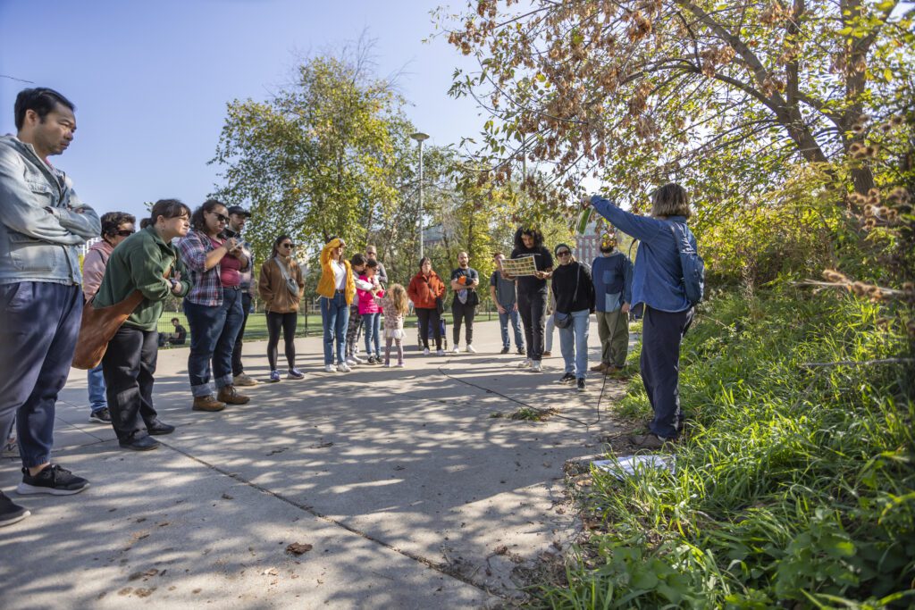 Group of people gathered around a speaker on tour of local plants.